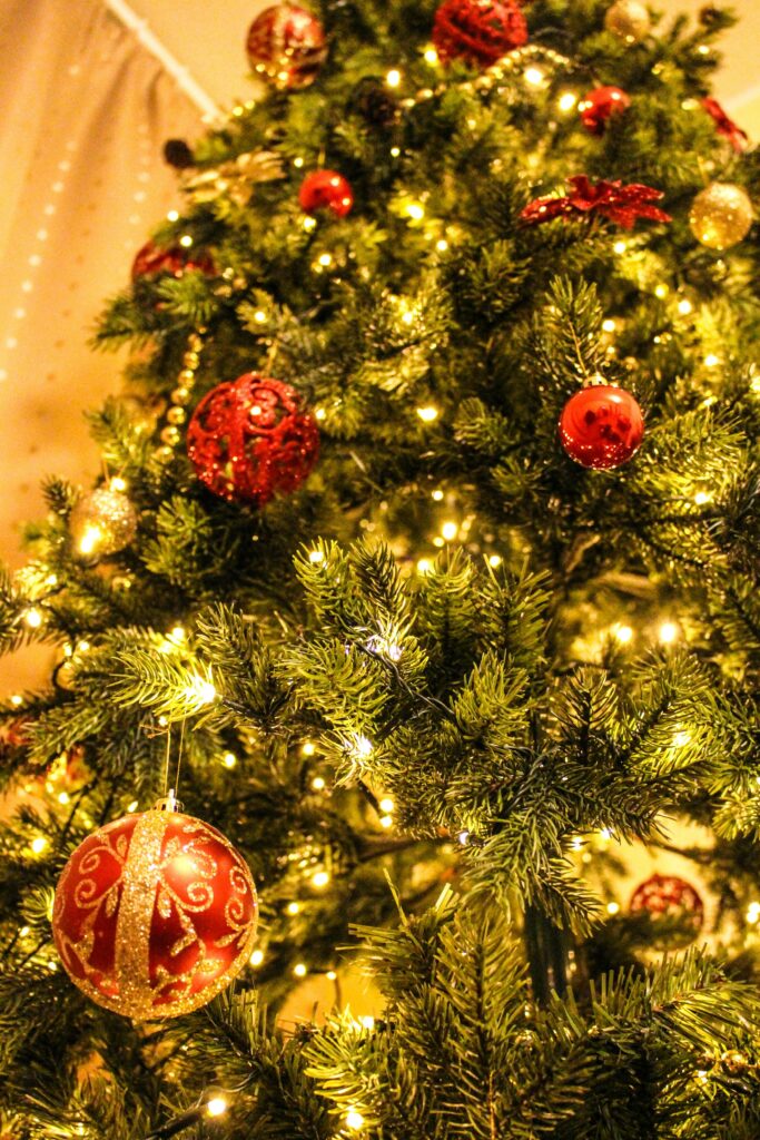 pexels-photo-246356-246356 Close-up of a decorated Christmas tree featuring golden lights and red ornaments.